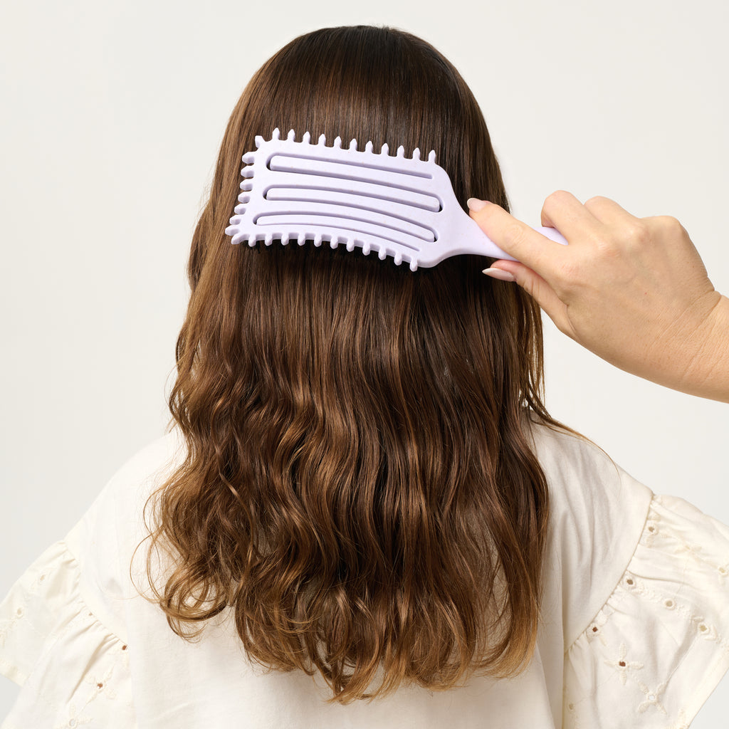 PixieYou Cloud Brush being used on wavy hair, showcasing its unique design and gentle detangling features.