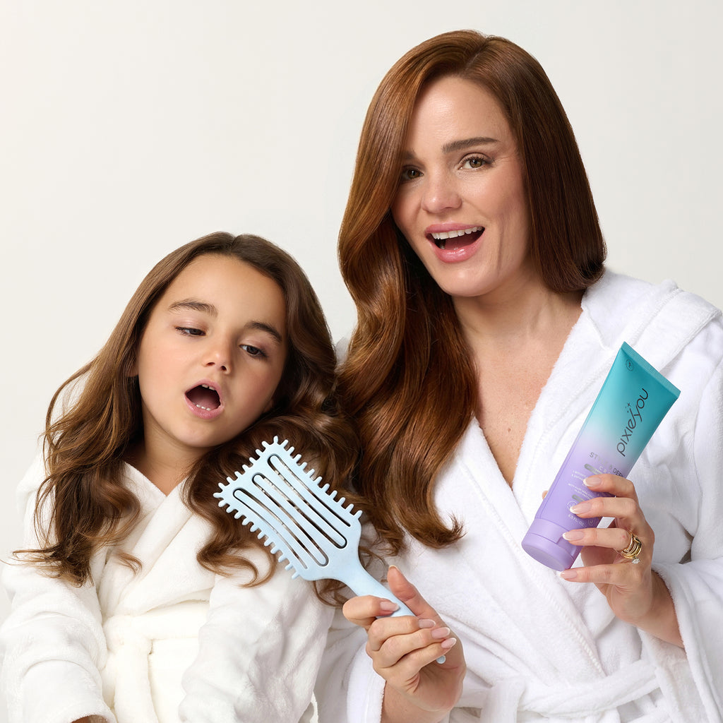PixieYou Cloud Brush held by a woman and a girl, both in white robes, showcasing shiny, styled hair.