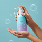 PixieYou Conditioner in a pump bottle held in a hand, with bubbles and a light blue background. 8.5 fl oz (250 ml).