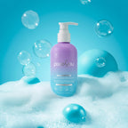 PixieYou Shampoo bottle in purple with a pump, surrounded by bubbles and blue spheres on a bright blue background.