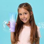 PixieYou Leave-in styling product held by a smiling girl with long hair, surrounded by bubbles against a blue background.