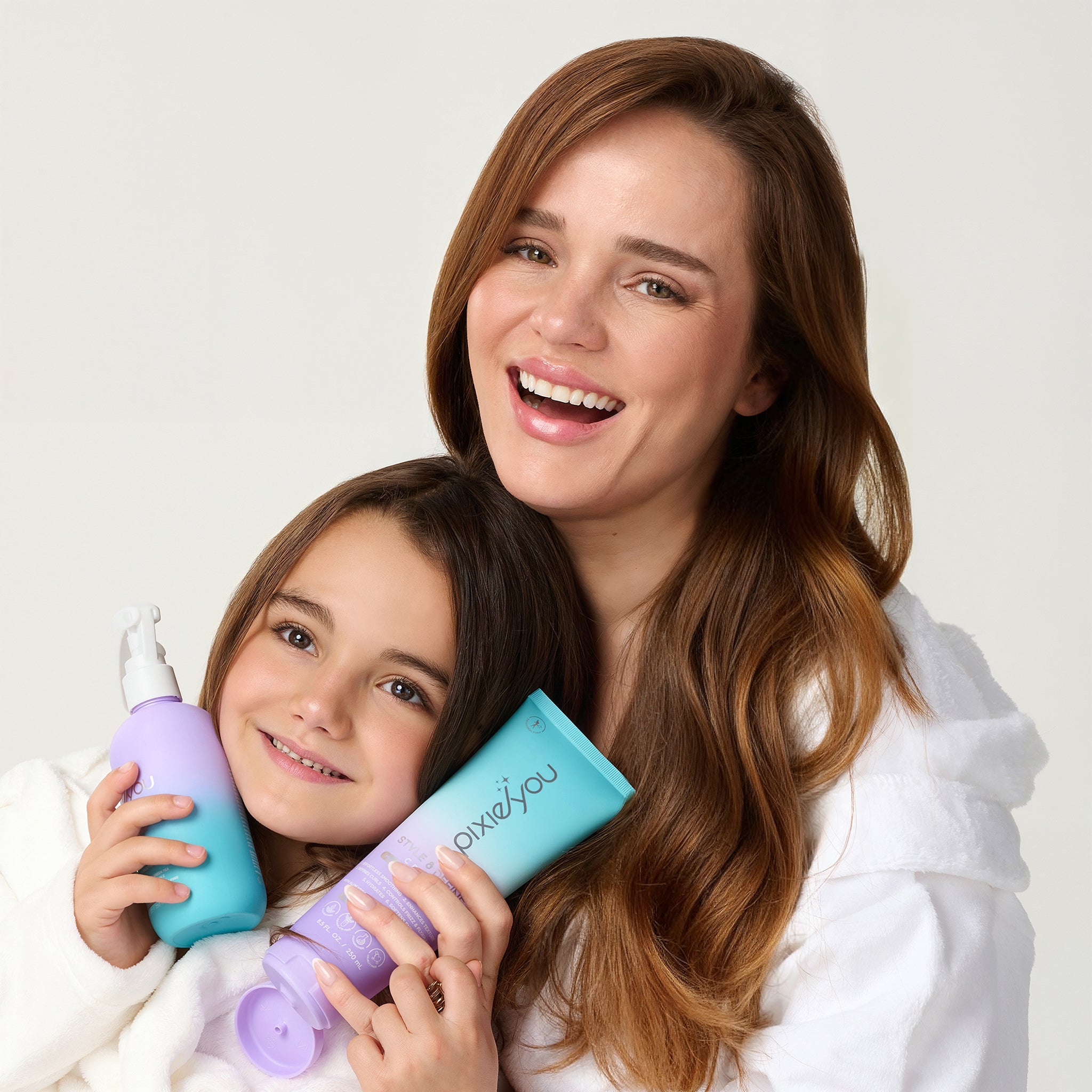 PixieYou Leave-in product image featuring a woman and a girl smiling, holding colorful hair care bottles.