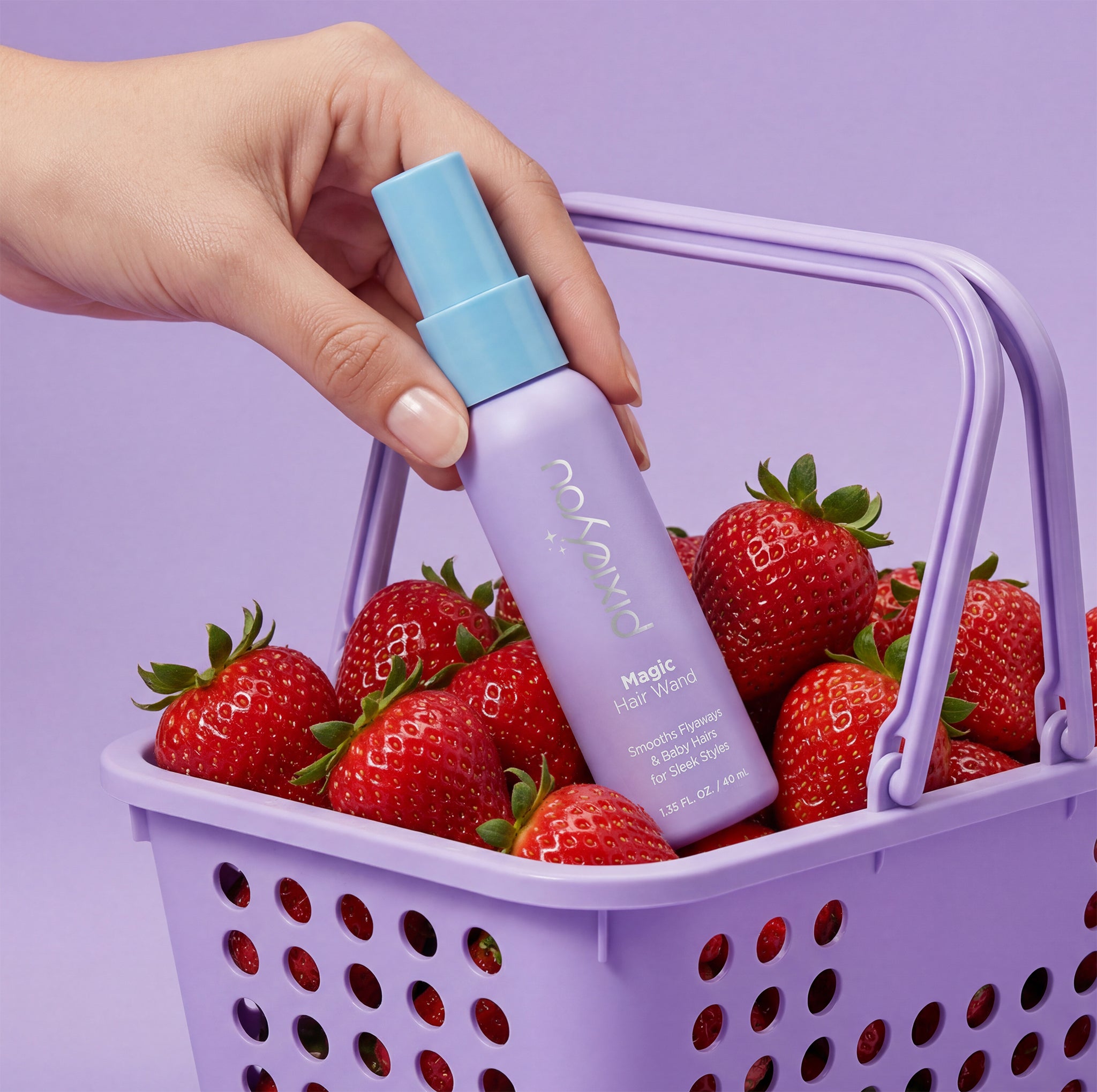 PixieYou Magic Wand hair spray in a lavender bottle, placed in a purple basket filled with fresh strawberries.
